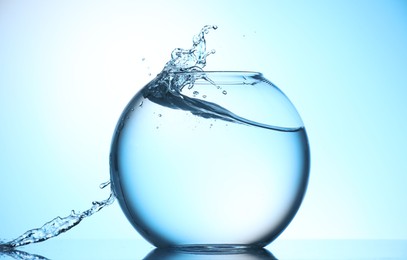 Photo of Glass aquarium with water on light blue background
