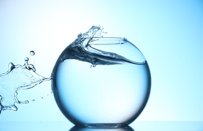 Photo of Glass aquarium with water on light blue background