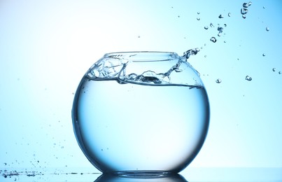 Photo of Glass aquarium with water on light blue background