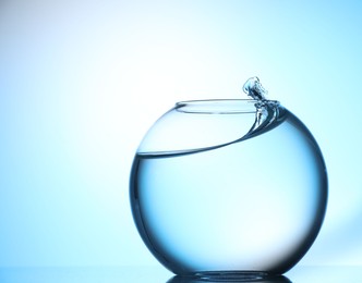 Photo of Glass aquarium with water on light blue background