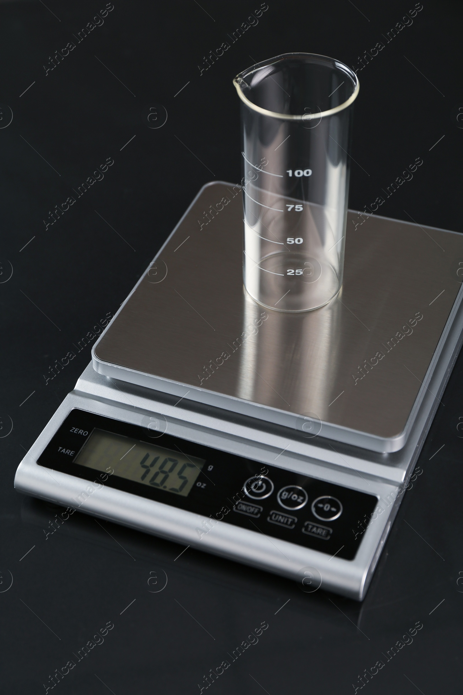 Scale with empty beaker on black mirror table, closeup Photo of Scale with empty beaker on black mirror table, closeup