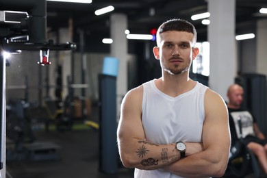 Photo of Portrait of professional personal trainer in gym. Space for text