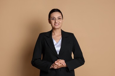Photo of Confident business woman in suit on beige background