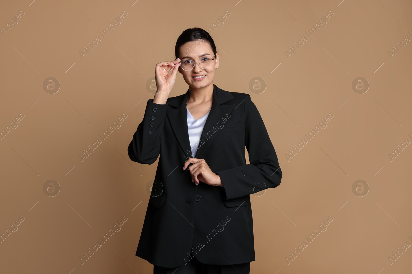 Confident business woman in suit on beige background Photo of Confident business woman in suit on beige background