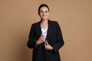 Photo of Confident business woman in suit on beige background