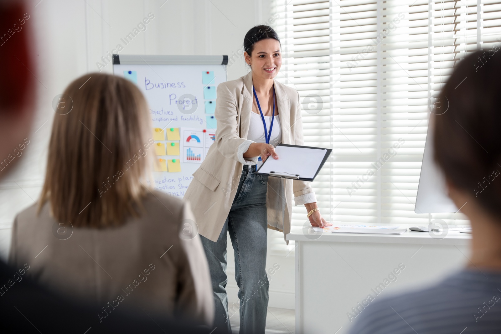 Woman giving public speech in front of audience indoors Photo of Woman giving public speech in front of audience indoors