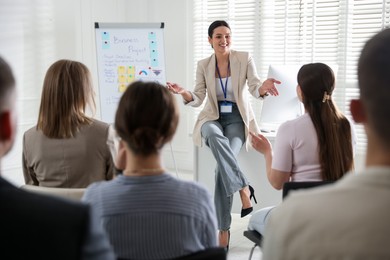 Photo of Woman giving public speech in front of audience indoors