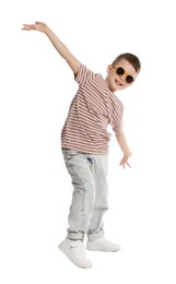 Photo of Happy little boy in sunglasses dancing on white background