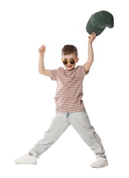 Photo of Happy little boy in sunglasses holding baseball hat and dancing on white background