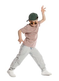 Photo of Funny little boy in sunglasses and baseball hat dancing on white background