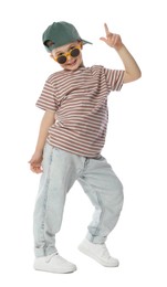 Photo of Happy little boy in sunglasses and baseball hat dancing on white background