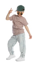 Photo of Happy little boy in sunglasses and baseball hat dancing on white background