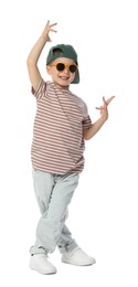 Photo of Happy little boy in sunglasses and baseball hat dancing on white background