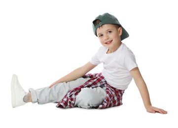 Photo of Happy little boy in baseball hat dancing on white background