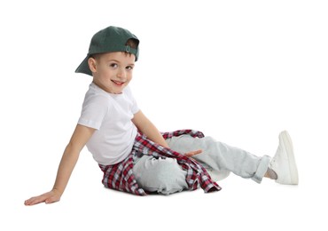Photo of Happy little boy in baseball hat dancing on white background