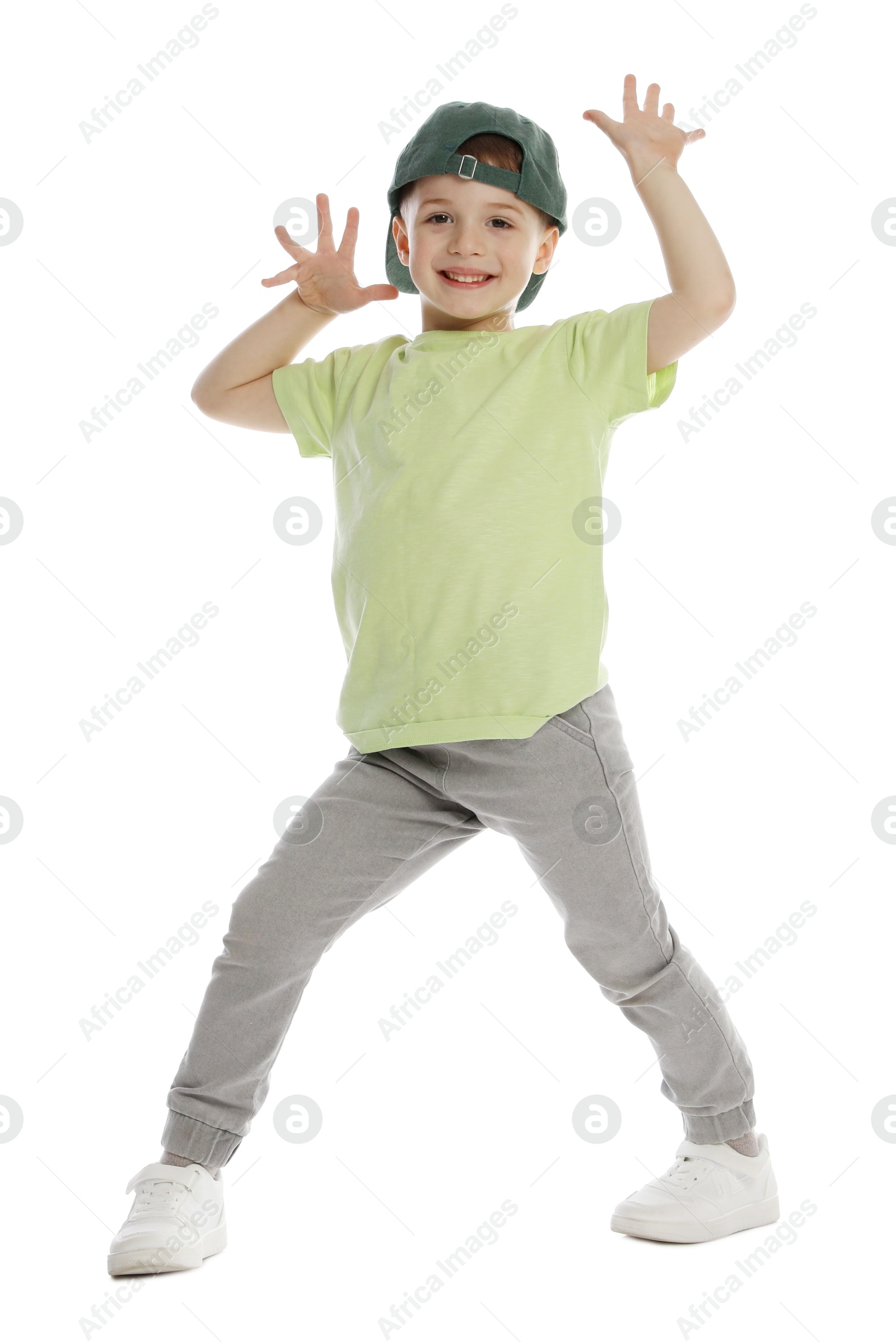 Happy little boy in baseball hat dancing on white background Photo of Happy little boy in baseball hat dancing on white background