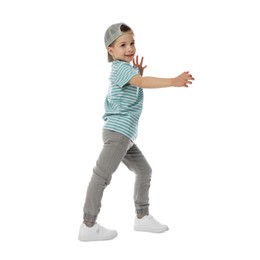 Photo of Happy little boy in baseball hat dancing on white background