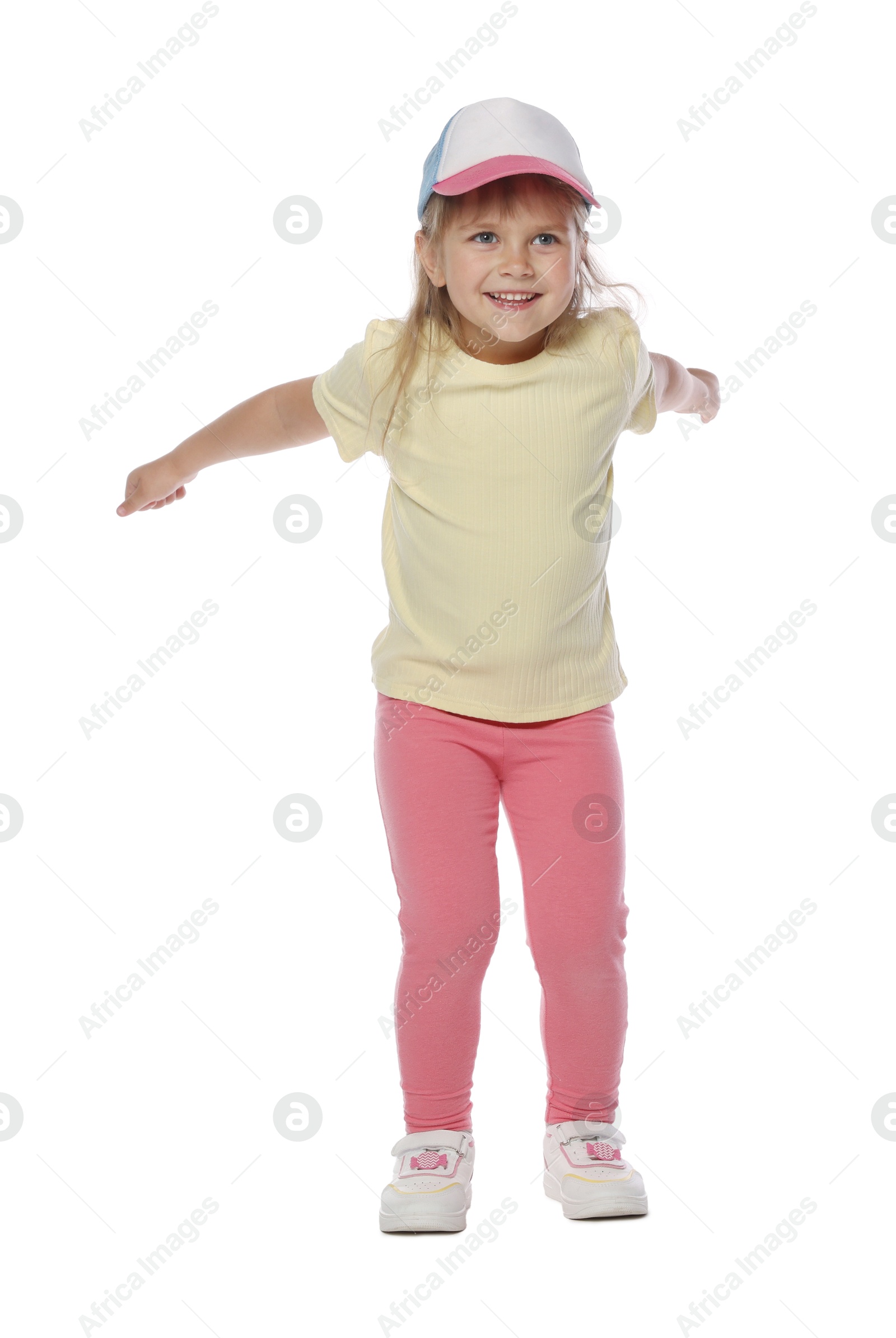 Photo of Happy little girl in baseball hat dancing on white background