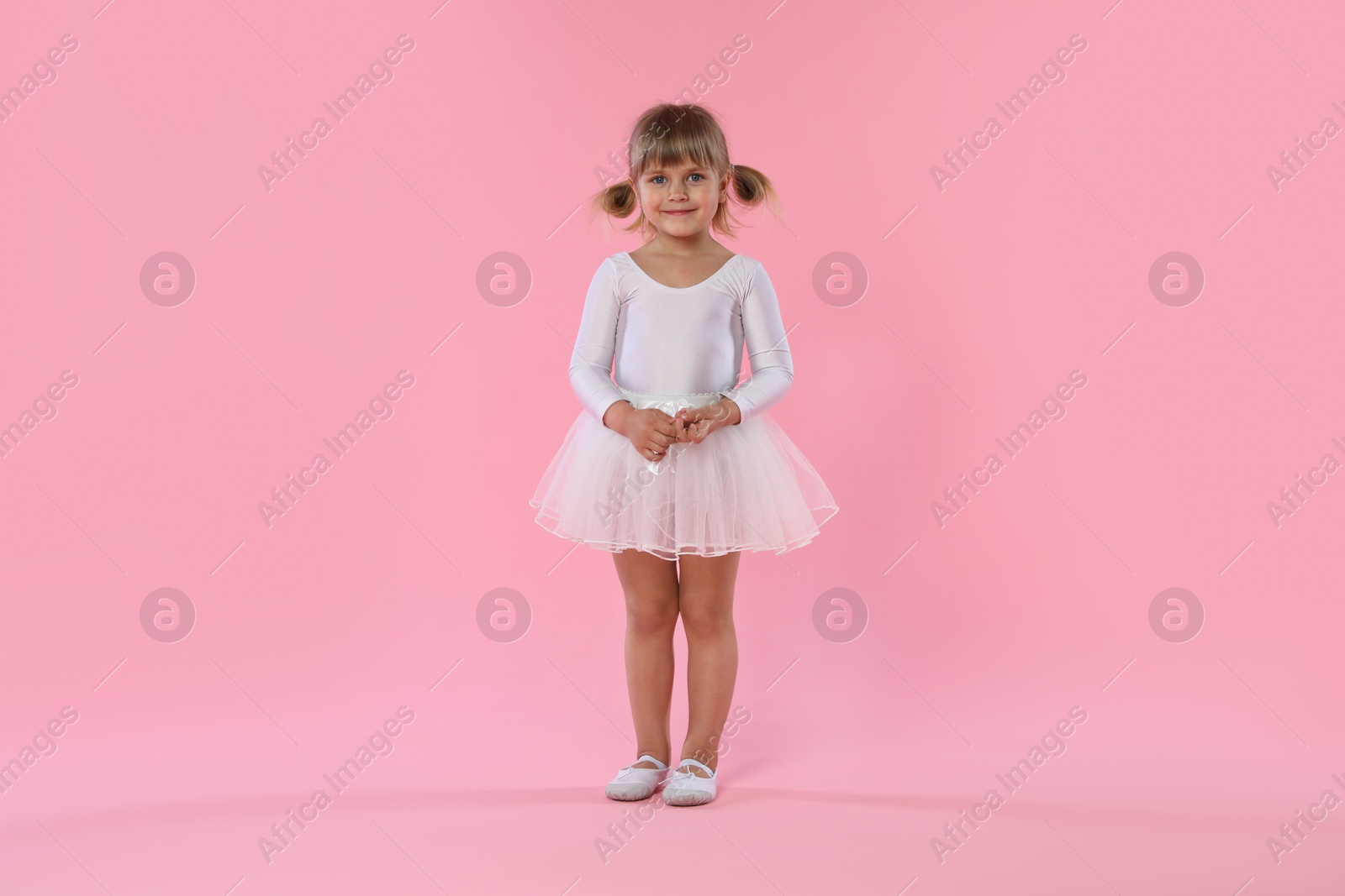 Cute little girl dancing on pink background Photo of Cute little girl dancing on pink background