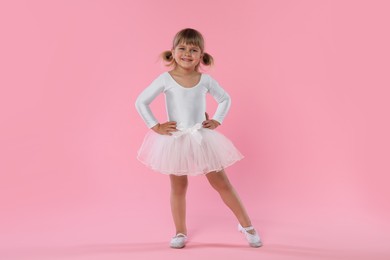 Photo of Cute little girl dancing on pink background