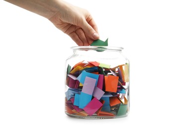 Photo of Woman taking color paper piece form glass jar on white background, closeup