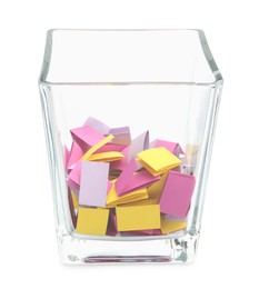Photo of Colorful paper pieces in glass holder isolated on white