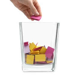 Photo of Woman taking color paper piece form glass holder on white background, closeup
