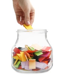 Photo of Woman taking color paper piece form glass jar on white background, closeup