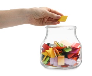 Photo of Woman taking color paper piece form glass jar on white background, closeup