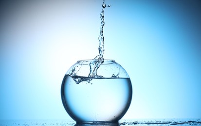 Photo of Glass aquarium with water on light blue background