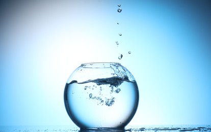 Photo of Glass aquarium with water on light blue background