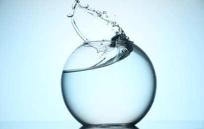 Photo of Glass aquarium with water on light blue background
