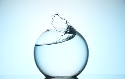 Photo of Glass aquarium with water on light blue background