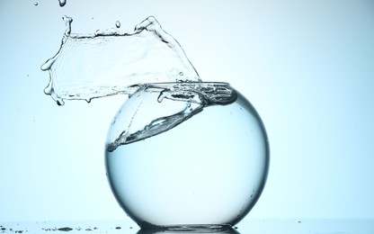 Photo of Glass aquarium with water on light blue background