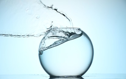 Photo of Glass aquarium with water on light blue background