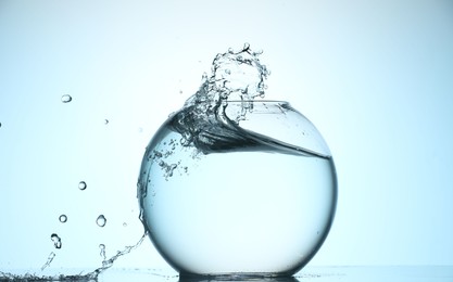 Photo of Glass aquarium with water on light blue background