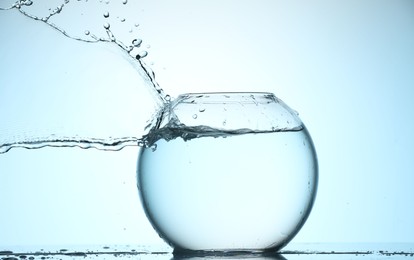 Photo of Glass aquarium with water on light blue background