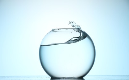 Photo of Glass aquarium with water on light blue background