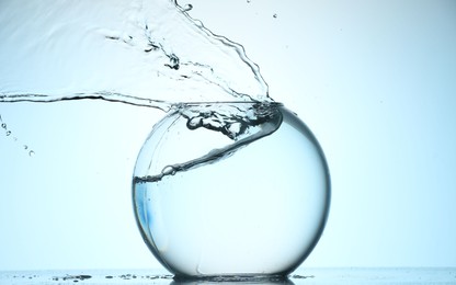 Photo of Glass aquarium with water on light blue background
