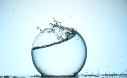 Photo of Glass aquarium with water on light blue background
