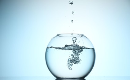 Photo of Glass aquarium with water on light blue background