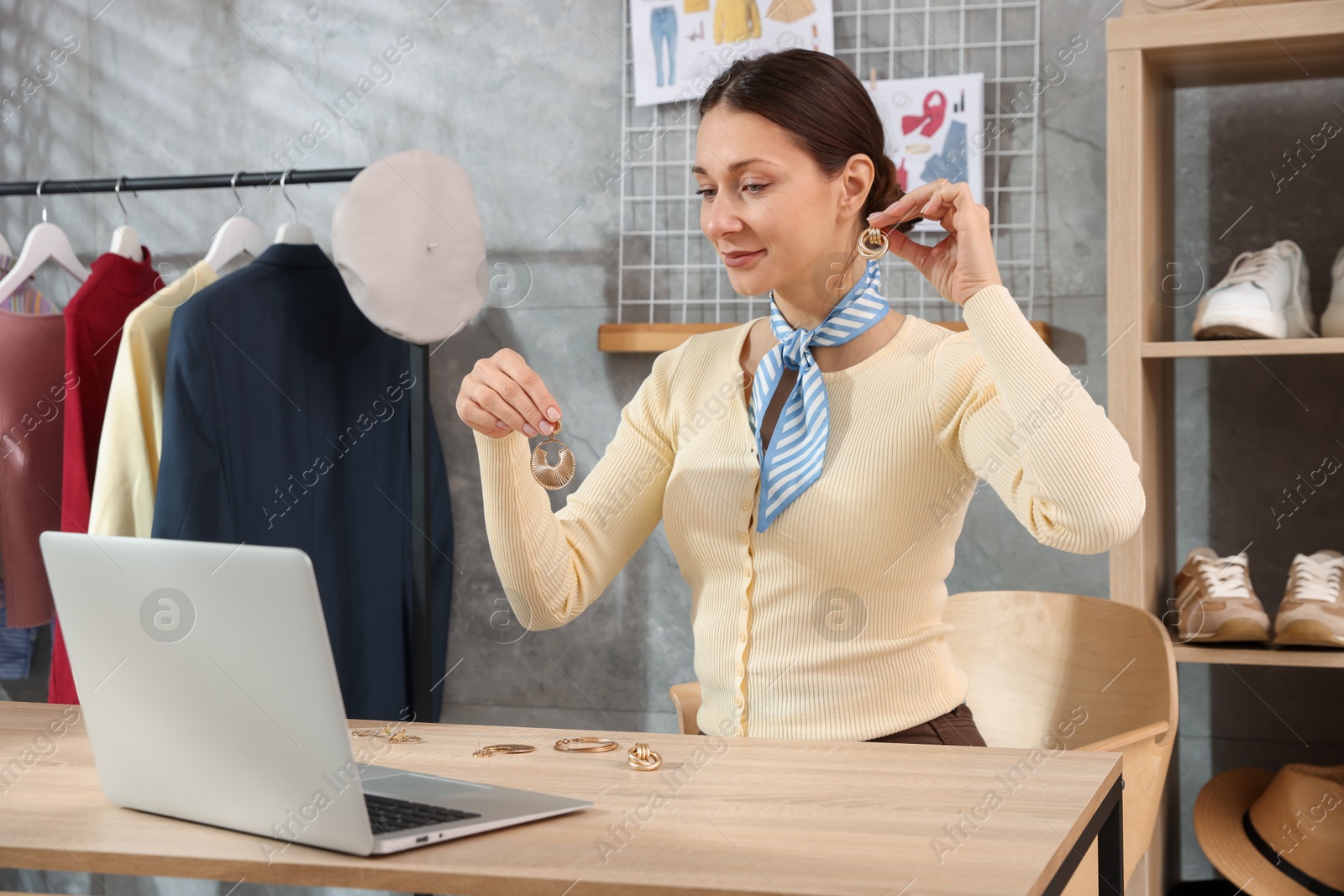 Photo of Professional stylist having online consultation with client via laptop at desk indoors