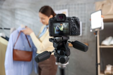 Photo of Professional stylist filming video on camera indoors, selective focus
