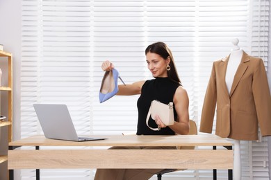 Photo of Professional stylist having online consultation with client via laptop at desk indoors