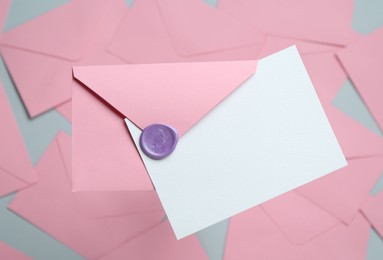 Photo of Blank invitation card and envelope on glass surface, top view. Space for design