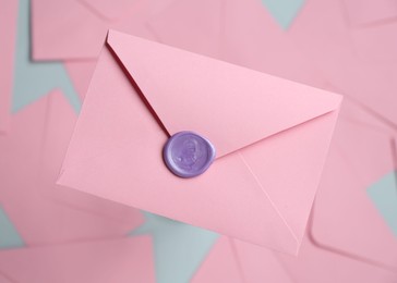 Photo of Beautiful invitation envelope with wax seal on glass surface, top view