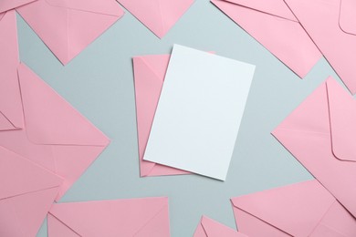 Photo of Blank invitation card and envelopes on grey background, flat lay. Space for design
