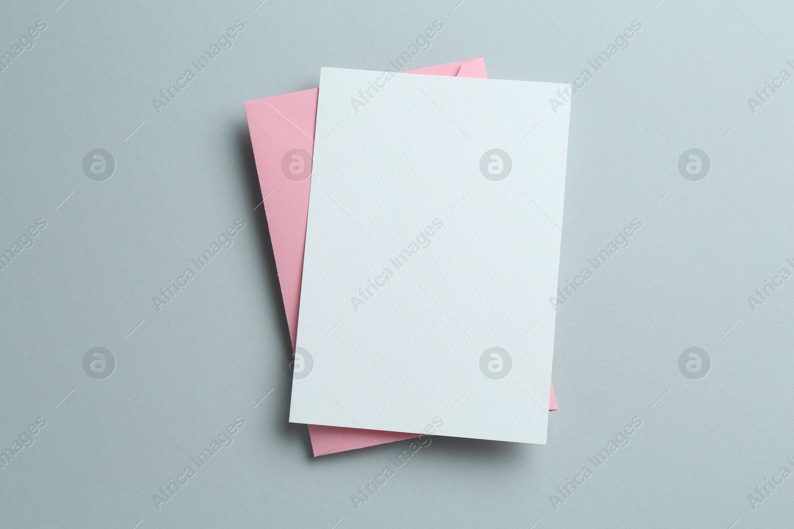 Blank invitation card and envelope on grey background, top view. Space for design Photo of Blank invitation card and envelope on grey background, top view. Space for design