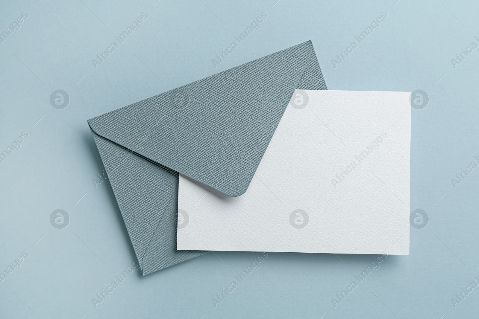 Blank invitation card and envelope on grey background, top view. Space for design Photo of Blank invitation card and envelope on grey background, top view. Space for design