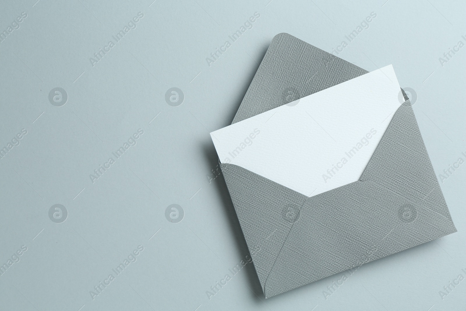 Blank invitation card and envelope on grey background, top view. Space for text Photo of Blank invitation card and envelope on grey background, top view. Space for text